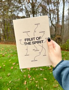 a person holding up a book with the words fruit of the spirit written on it