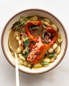 a bowl filled with beans and vegetables next to a spoon