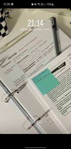 an open notebook sitting on top of a desk next to a pen