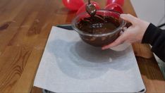 someone is dipping chocolate into a glass bowl