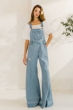 Choose comfort and style with the Women's Distressed Wide Leg Denim Overall. The adjustable straps, kangaroo chest pocket, and front and back pockets provide convenience, while the wide western legs, side buttons, and distressed accents add a trendy touch. Stay on trend in these comfortable, boho-inspired overalls. 34" INSEAM SLEEVELESSBUCKLE CLOSUREADJUSTABLE STRAPSKANGAROO CHEST POCKETFRONT/BACK POCKETSWIDE LEG Women’s Overall Outfits, Aesthetic Denim Outfits, Denim Party Outfit For Women, Wide Leg Light Wash Overalls With Pockets, Trendy Washed Blue Relaxed Fit Overalls, Relaxed Fit Denim Wide Leg Overalls, Overall Outfits Women, Boho Overalls Outfits, Coastal Cowgirl Overalls