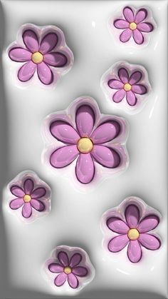 some pink and purple flowers on a white surface