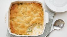 a casserole dish with meat and vegetables in it next to a bowl of soup