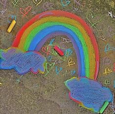 a child's drawing with chalk and crayons on the ground next to a rainbow