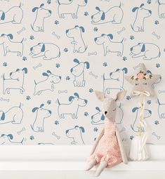 a stuffed animal sitting on top of a shelf next to a wall with dogs and paw prints