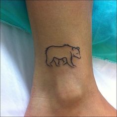 a small bear tattoo on the ankle