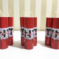 four red candles wrapped in paper and tied with twine on top of each other