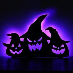 three pumpkins with faces carved into them in front of a purple background and the words happy halloween written on it