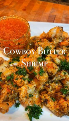 a white plate topped with shrimp next to a small bowl of chili and seasoning