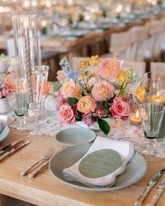 the table is set with flowers and silverware