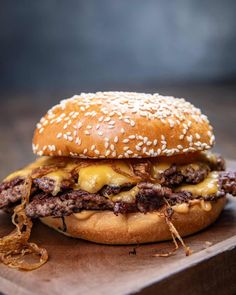 a cheeseburger on a wooden cutting board