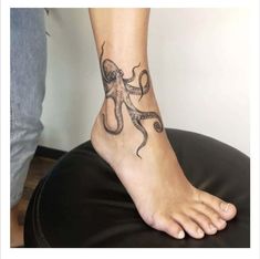 an octopus tattoo is on the foot of a person who is sitting in a chair