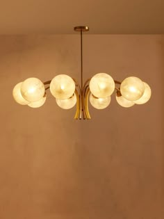 a chandelier hanging from the ceiling in a room with beige walls and flooring