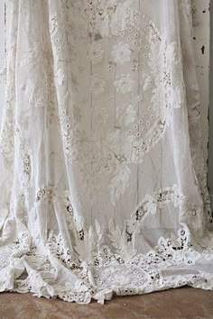 an old white curtain with lace on it