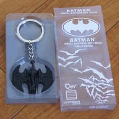 a batman metal keychain is in the packaging