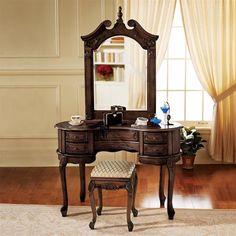 an antique vanity with mirror and stool in a room