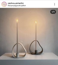 two candles sitting on top of a white table