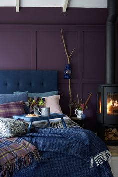 a bedroom with purple walls and blue upholster