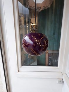 a purple ball hanging from the side of a window