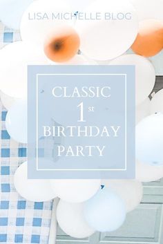 a blue and white birthday party with balloons on the table, text classic 1st birthday party