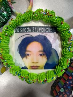 a cake decorated with green frosting and an image of a woman's face