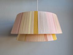 a multicolored lamp shade hanging from a ceiling fixture in a living room or bedroom