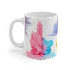 a white coffee mug with colorful paint splattered on it