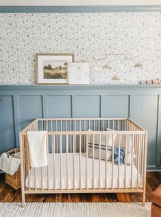 a baby crib in the corner of a room with blue walls and wood flooring