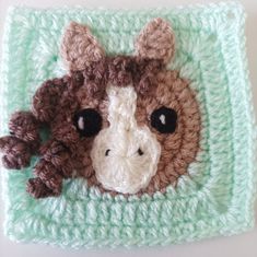 a crocheted square with a giraffe's head on it and eyes