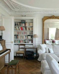 a living room filled with furniture and a grand piano in front of a large mirror