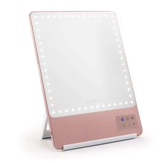 a pink and white lighted mirror on top of a table