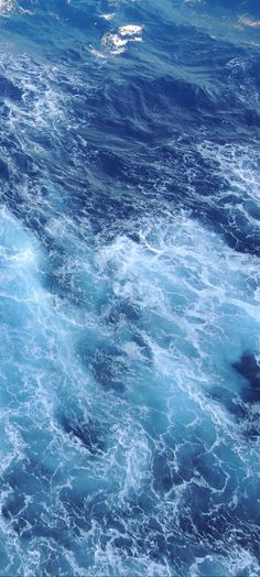 the water is blue and foamy as it moves through the ocean with small waves