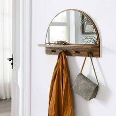 a mirror and coat rack hanging on a wall