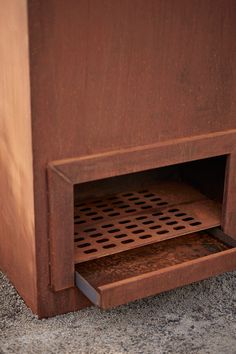 an open drawer on the side of a wooden cabinet that is sitting on concrete flooring