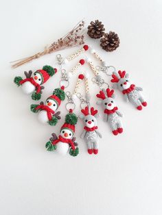 a group of knitted christmas ornaments with pine cones on the top and snowmen hanging from them