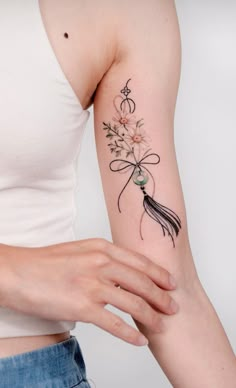 a woman with a tattoo on her arm holding a bouquet of flowers and a tatoo