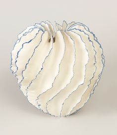 a white and blue striped apple sitting on top of a table