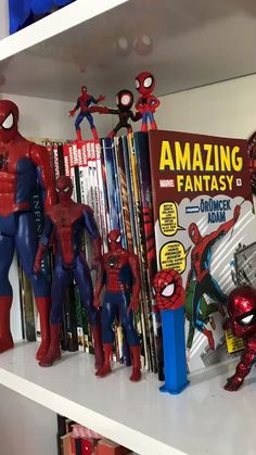 spiderman figurines are lined up on the shelves in a children's room