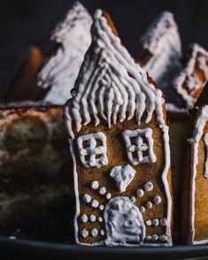 a gingerbread house is decorated with icing and white frosting on a plate