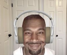 a man wearing headphones and smiling for the camera