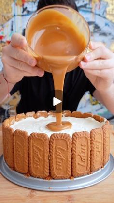 someone pouring caramel sauce on top of a cake