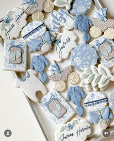 cookies decorated with blue and white designs are displayed on a tray, including baby's first year