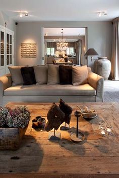 a living room filled with furniture and lots of pillows on top of a wooden floor