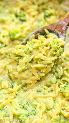 broccoli macaroni and cheese being stirred with a wooden spoon