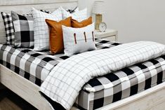 a bed with black and white checkered comforter, two pillows on the headboard