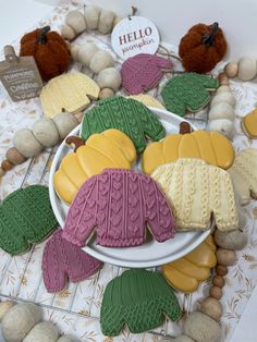 cookies decorated with knitted sweaters and leaves on a plate