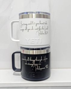 two coffee mugs sitting on top of a white shelf with the words yet printed on them