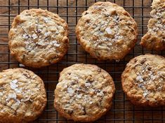 six cookies cooling on a wire rack with coconut flakes all over the top and bottom