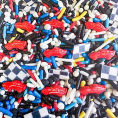 many different colored candies are scattered on top of each other in the shape of race cars