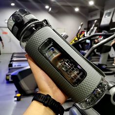 a person is holding an electronic device in their hand while on the treadmills